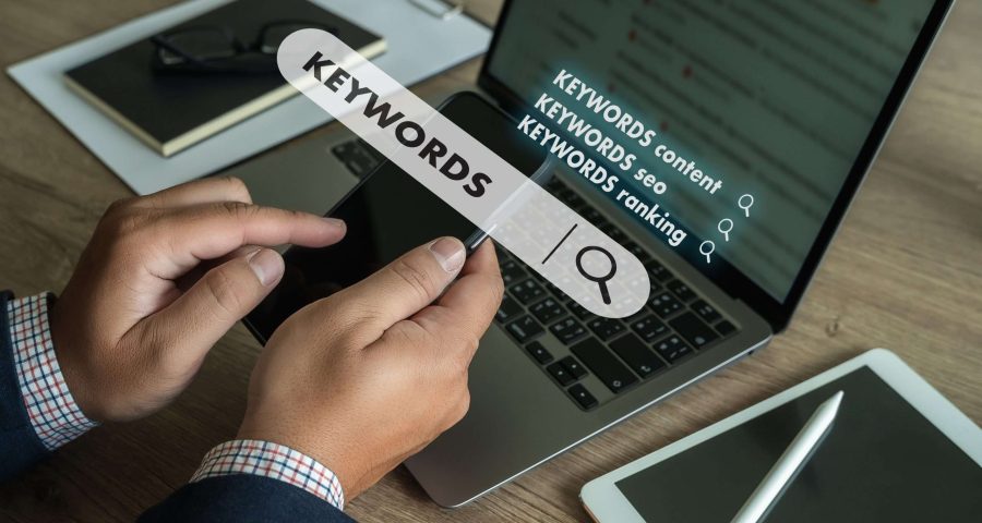 man searching on laptop with keywords popped up on a search bar