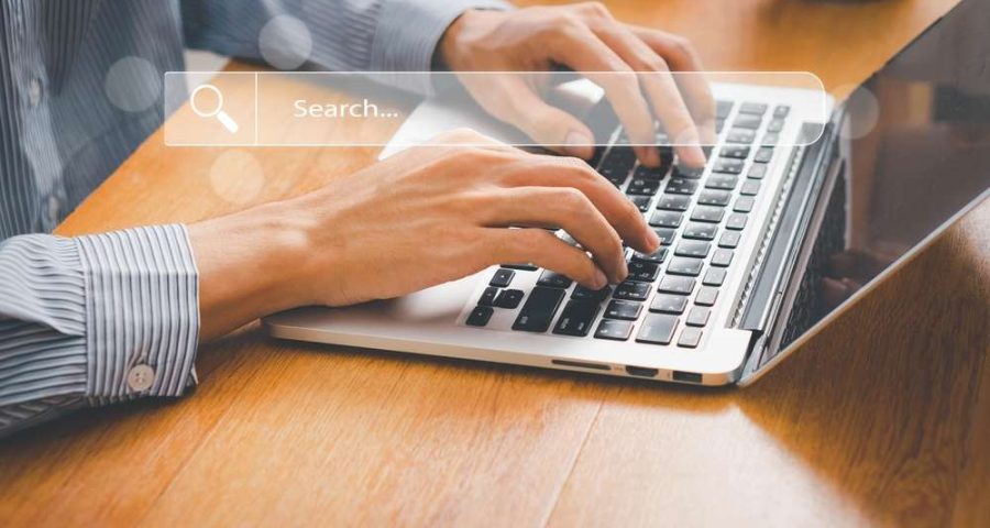 person on laptop with holographic search bar