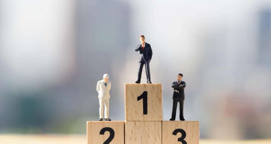 A photograph of toy men standing on a wooden podium.