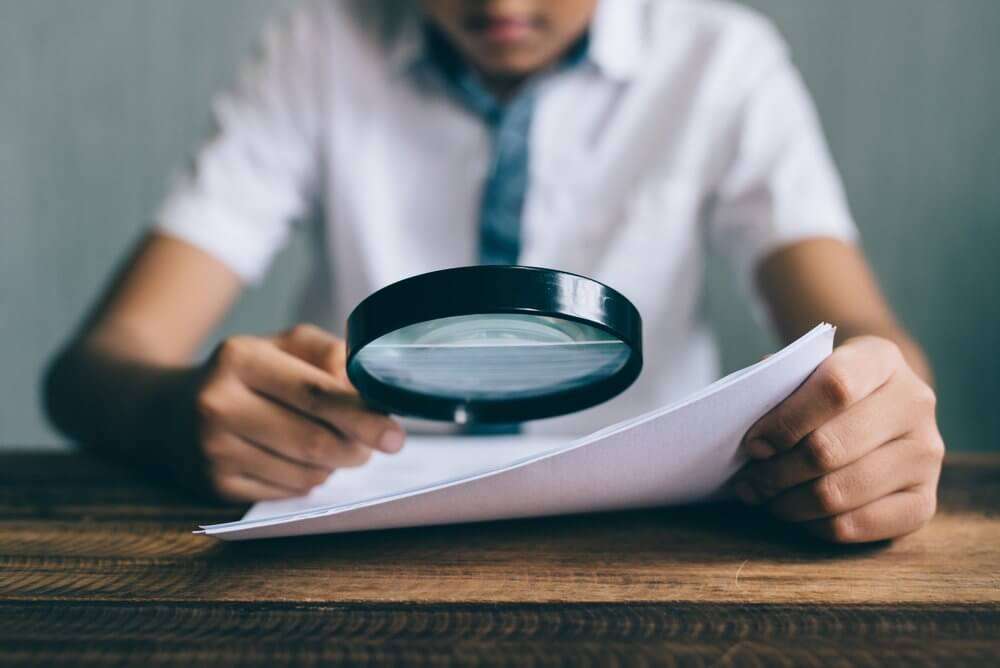 boy holding up magnifying glass